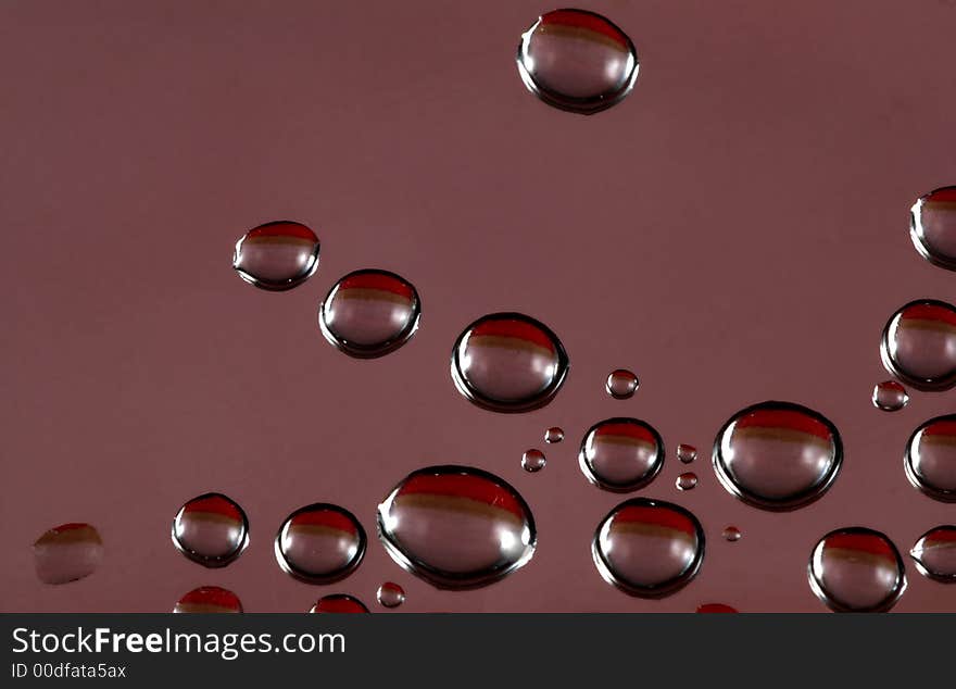 Water drops with red, black, and brown reflection