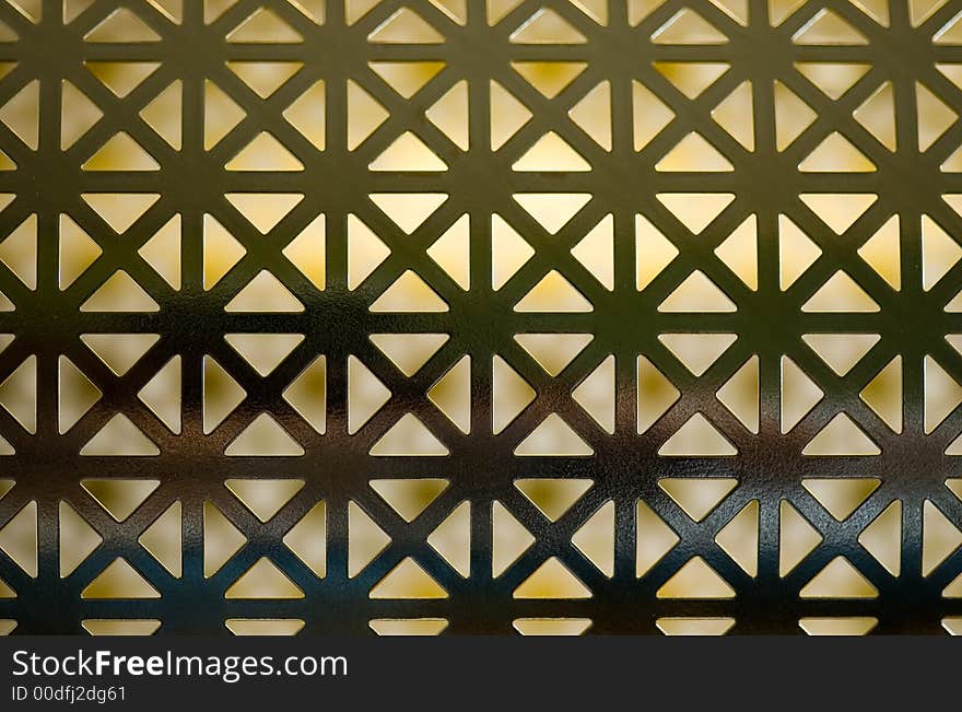 An abstract, symmetrical grid background with back lighting.  Pattern created by a round metal drum used for bingo number drawing. An abstract, symmetrical grid background with back lighting.  Pattern created by a round metal drum used for bingo number drawing.