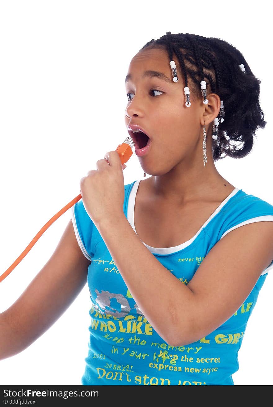 Young girl putting powercable in her mouth. Young girl putting powercable in her mouth