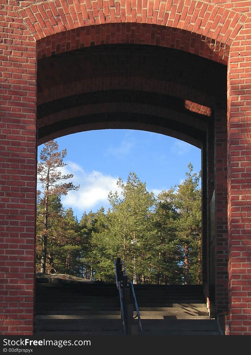 Red brick wall frame with blue sky and green trees. Red brick wall frame with blue sky and green trees