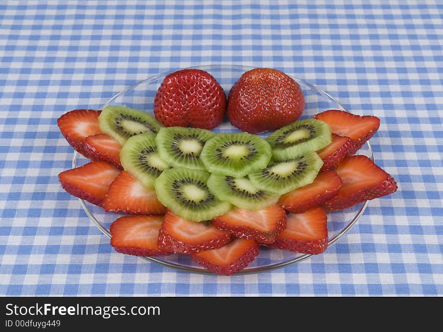 Strawberry, kiwi fruit plate on a blue and white checkerboard cloth