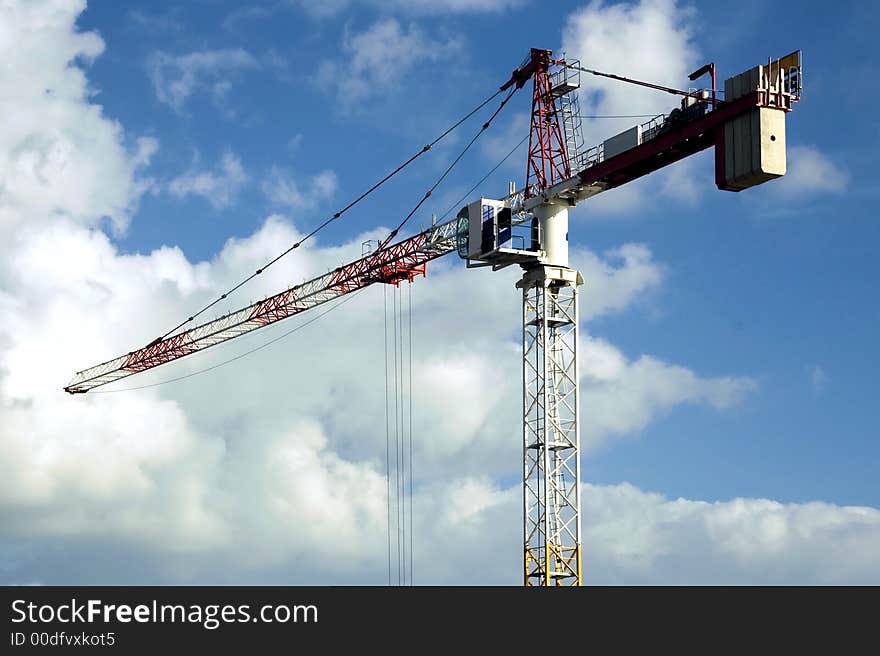 High rise crane with a cloudy blue sky backdrop