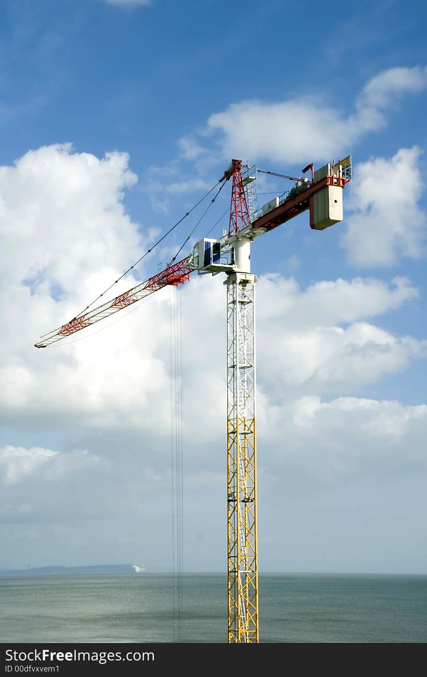 Tall crane doing high rise work near seafront