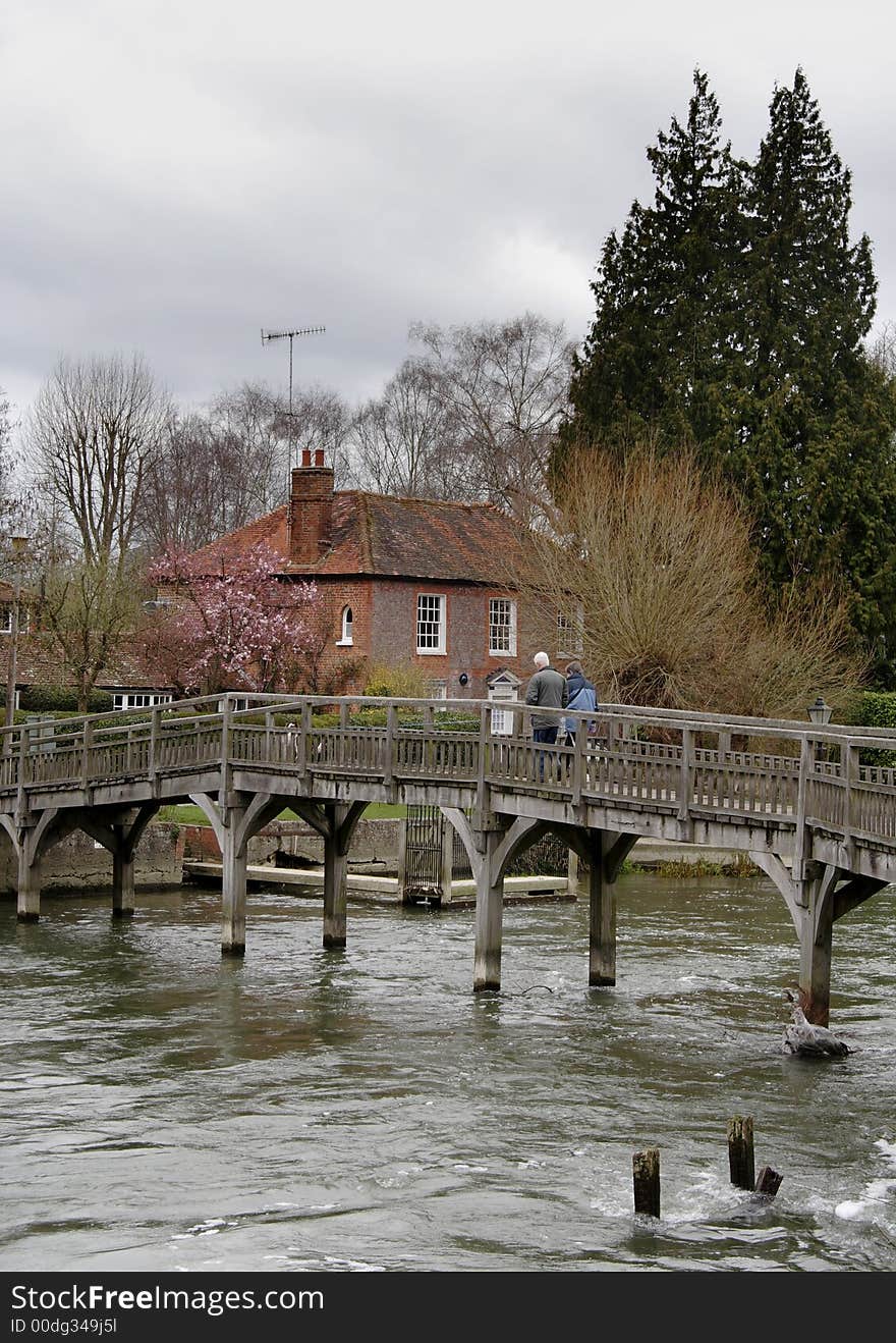 Wooden Footbridge over a Swollen River Thames in England  with people walking accross