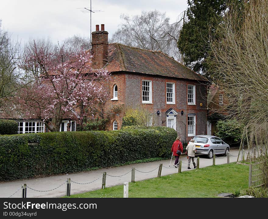 Quaint English Cottage next to a footpath with walkers going past. Quaint English Cottage next to a footpath with walkers going past.