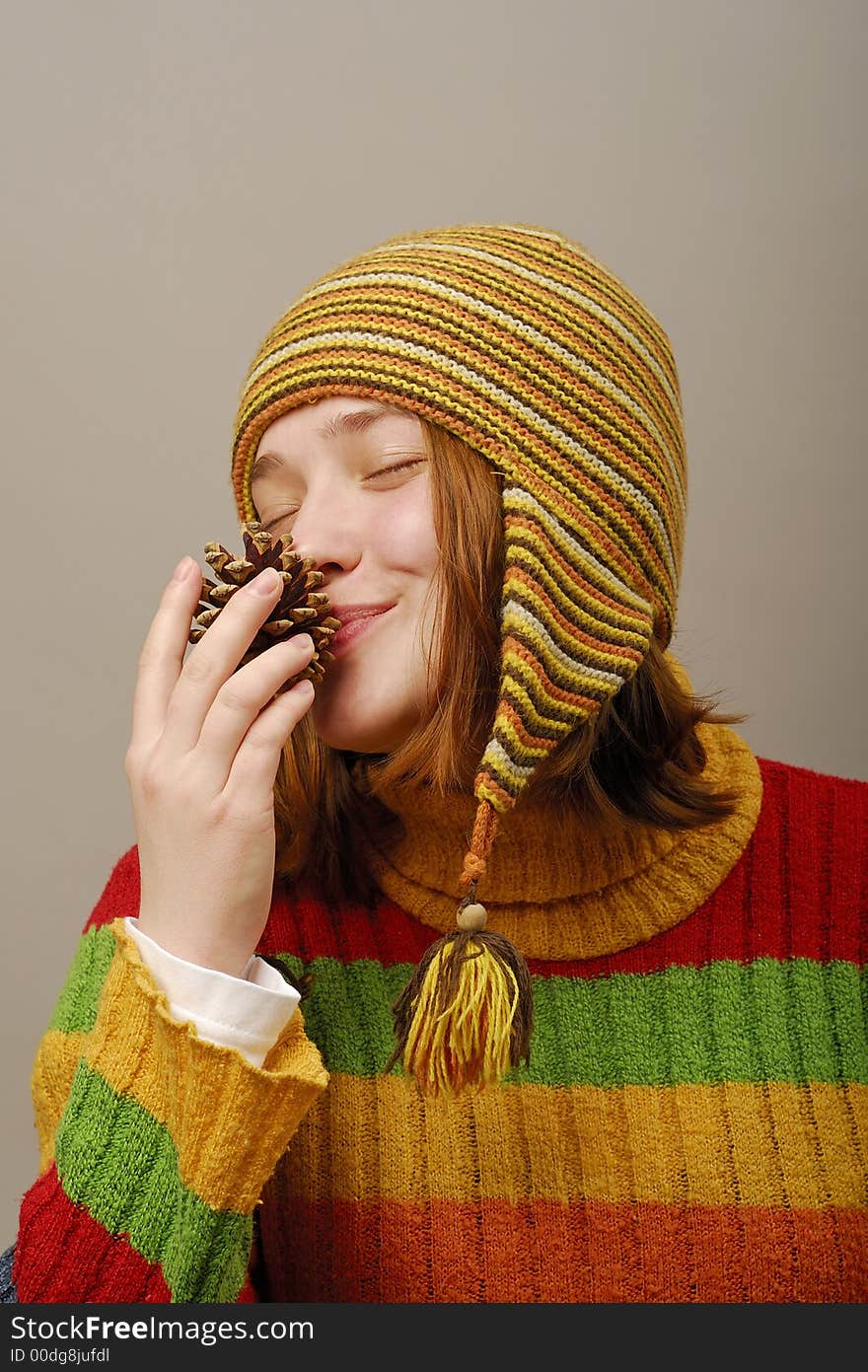 Girl in yellow cap smells fir apple. Girl in yellow cap smells fir apple