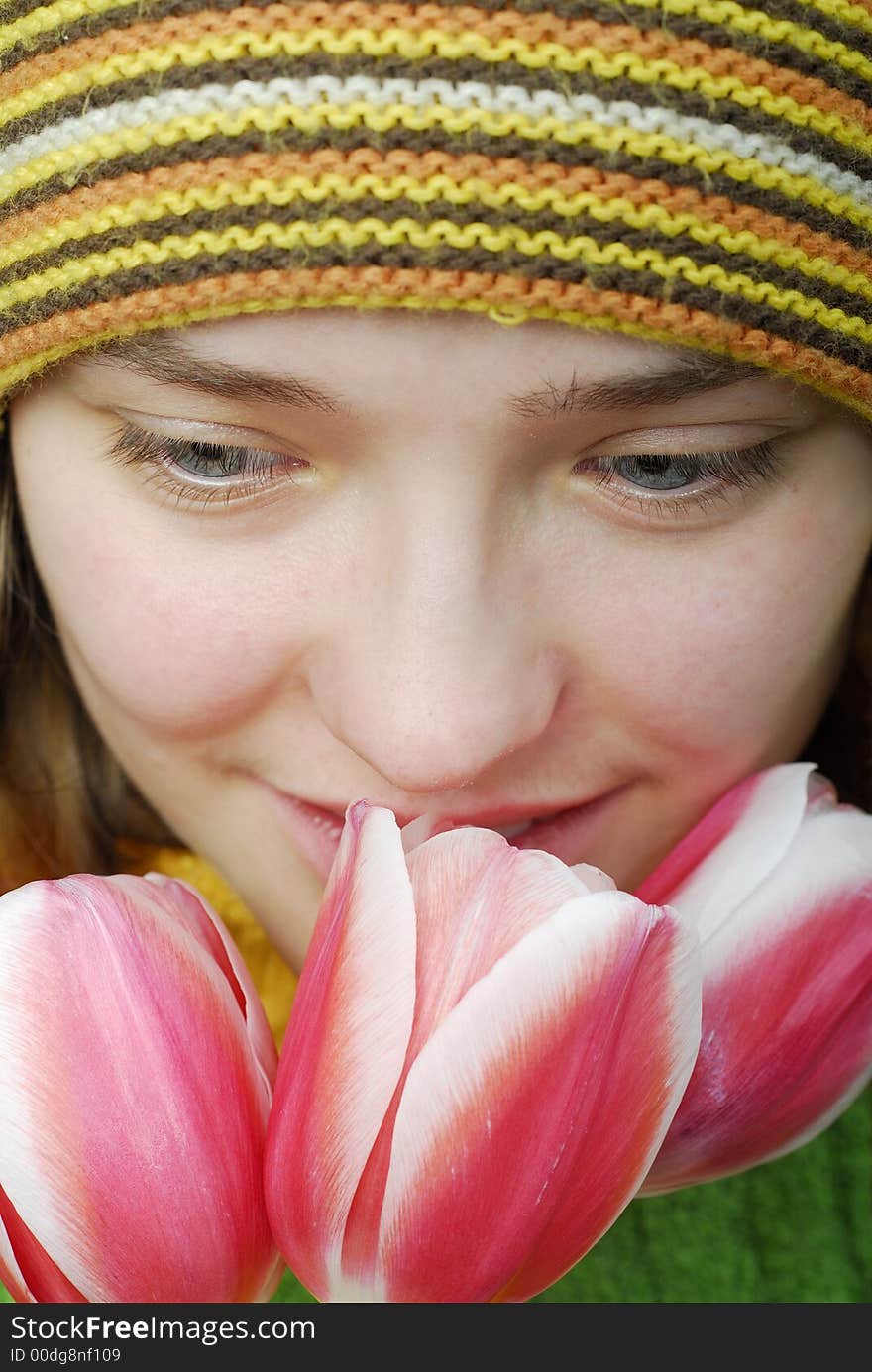 Girl in striped cap and face in pink tulips. Girl in striped cap and face in pink tulips.