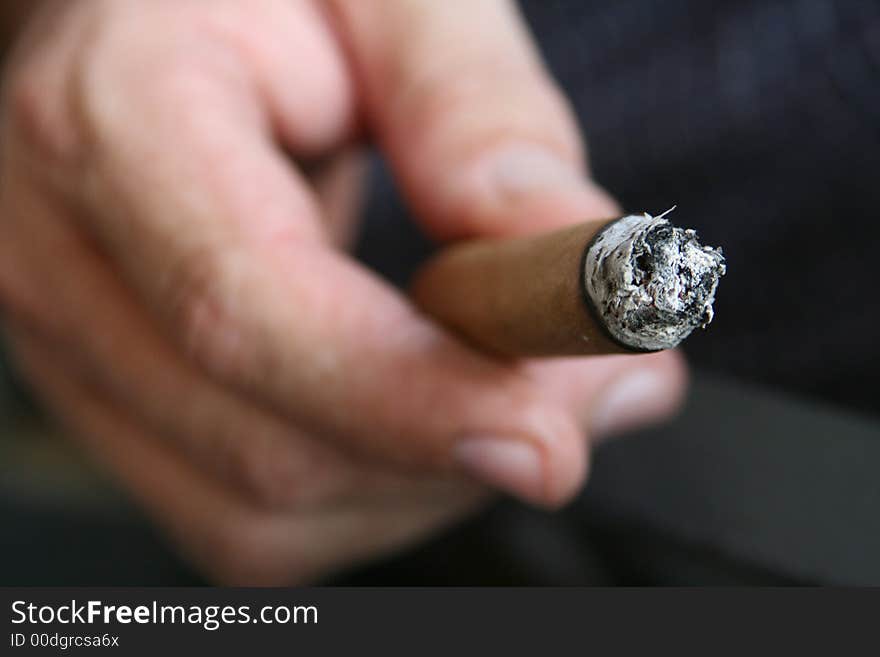 Man holding a burning cigar