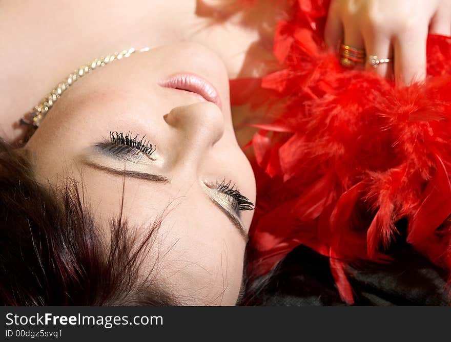 Woman with plumes. She is lying on bed. Woman with plumes. She is lying on bed.