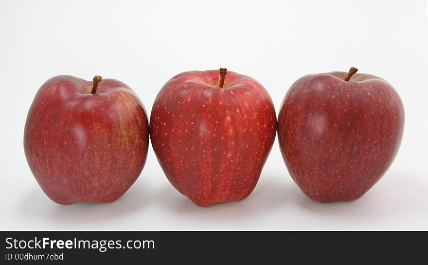 Three red apples on white background