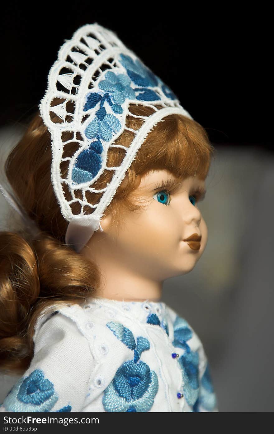 Doll in folk costume with blue traditional embroidery in Hungary.