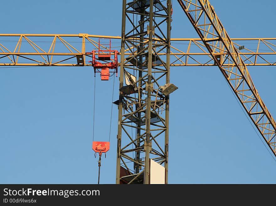 Criss crossing cranes on blue sky