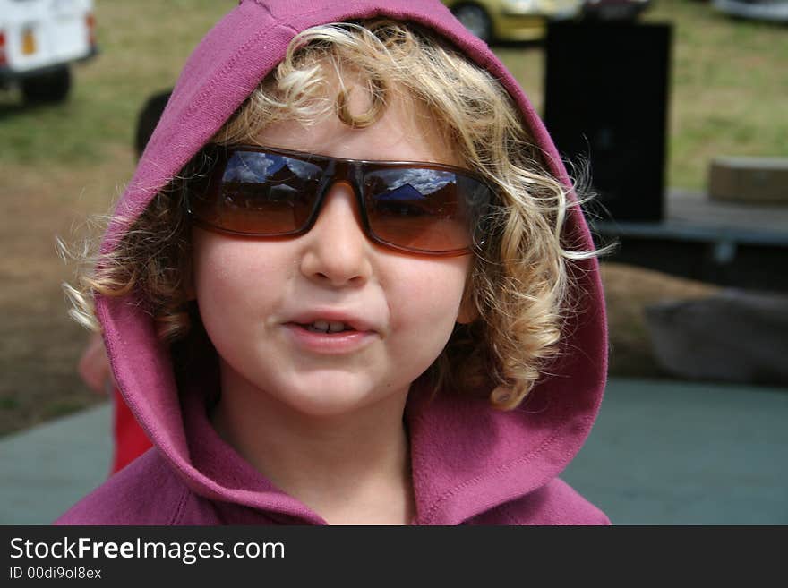 Little blond curly hair girl wearing sun glasses