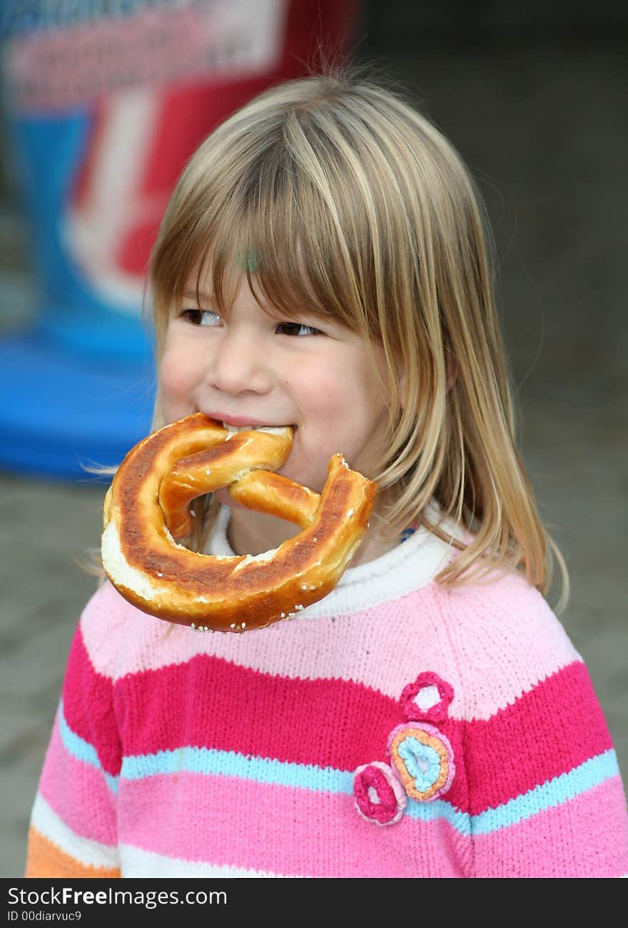 Little girl eating a piece of bread with her hands