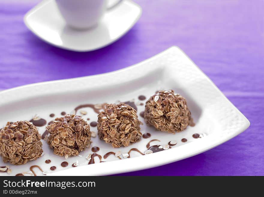 Sweets cakes with chocolate on the violet background