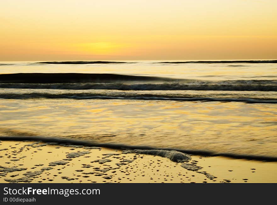 Ocean background (photo taken with slow shutterspeed) in golden colors