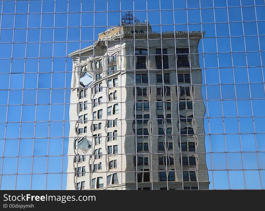 Reflection of older office structure in the windows of more contemporary building. Reflection of older office structure in the windows of more contemporary building