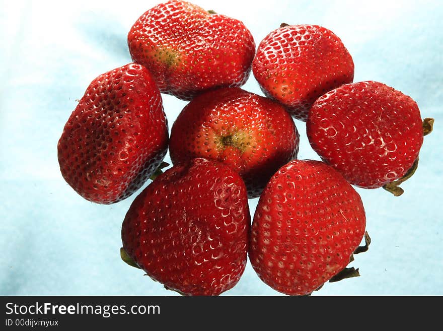 Seven strawberries on a light blue background