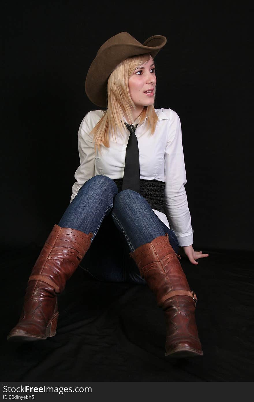 Beautiful blonde cowgirl in studio with cowboy hat