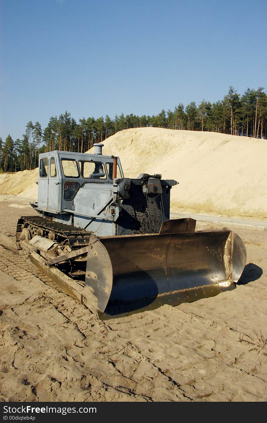 A excavator and forest in background