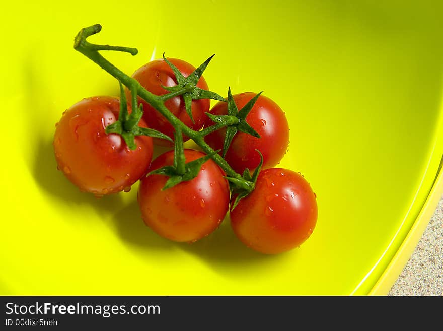 freshly washed tomatoes in a yellow bowl