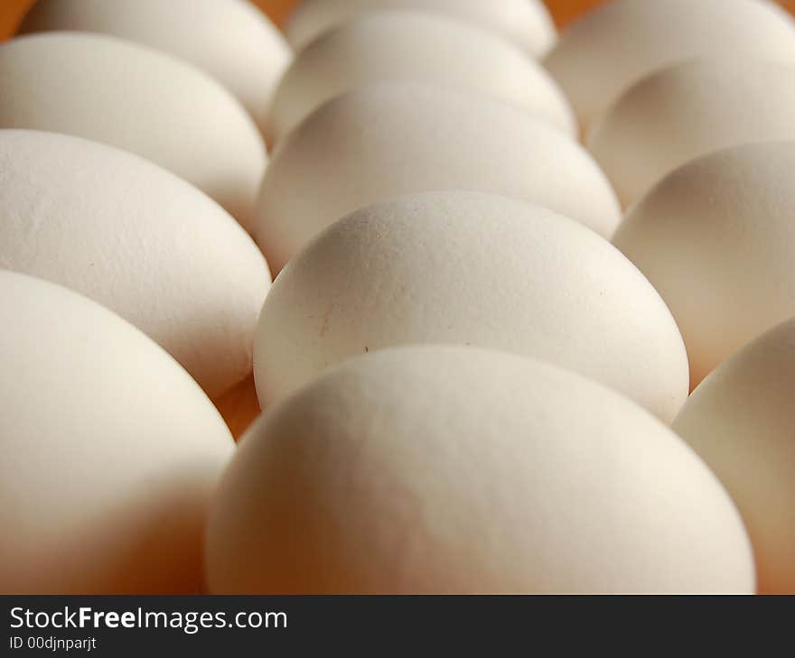 Heap of white eggs with focused detail of surface of one egg. Heap of white eggs with focused detail of surface of one egg