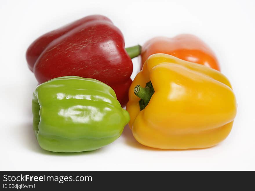 Four colorful peppers on white background