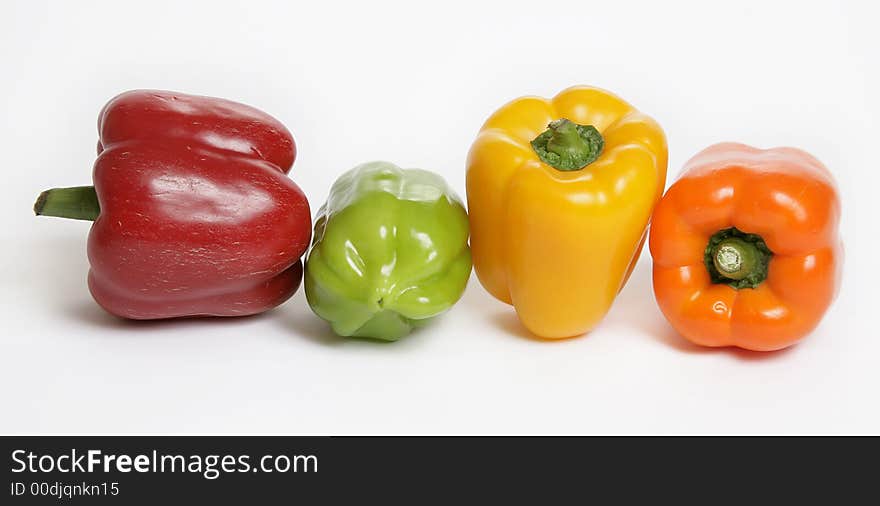 Four colorful peppers on white background