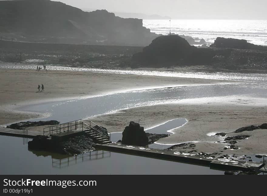 Misty beach scene with a old swimming pool in  the forefront