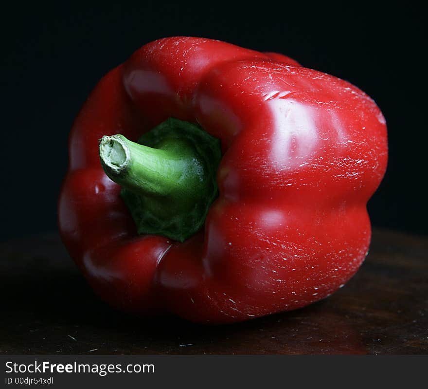 One red pepper on black background