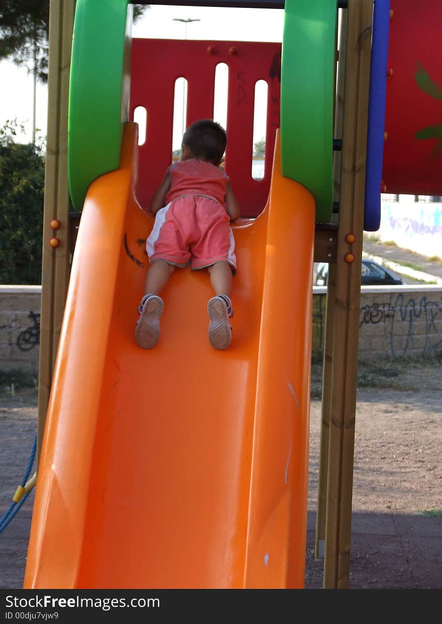 Little boy on orange sliding board. Little boy on orange sliding board