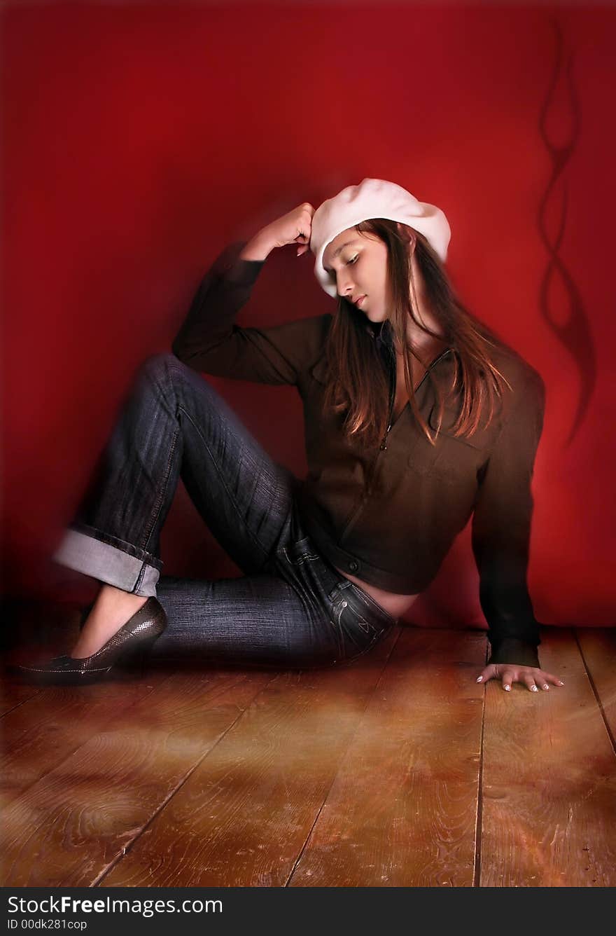 Young brunette with hat sitting on floor. Young brunette with hat sitting on floor