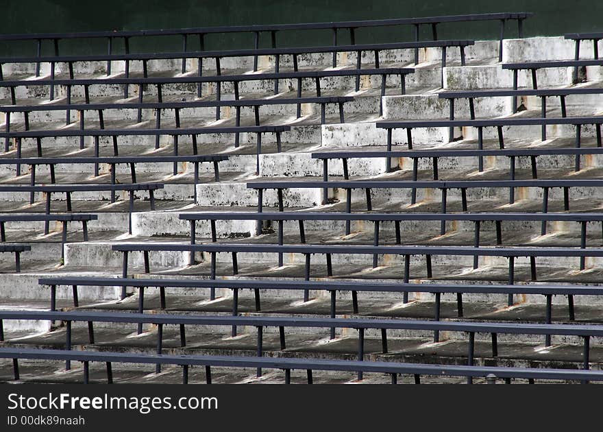 Blue Benches On A Grey Concrete Ground In Rows, Stadium Seats. Blue Benches On A Grey Concrete Ground In Rows, Stadium Seats