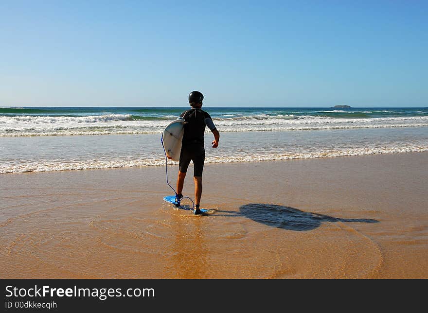 Suited up surfer heading out to catch some waves. Suited up surfer heading out to catch some waves.