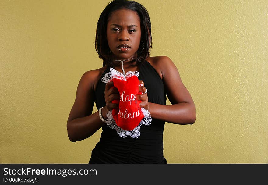 African american woman squeezing happy valentine pillow with angry expression