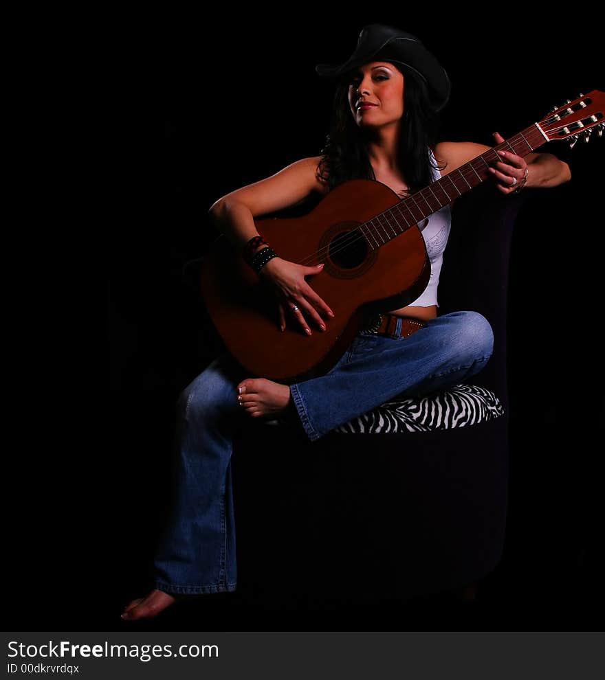 Classic country girl sitting on the sofa playing guitar. Classic country girl sitting on the sofa playing guitar