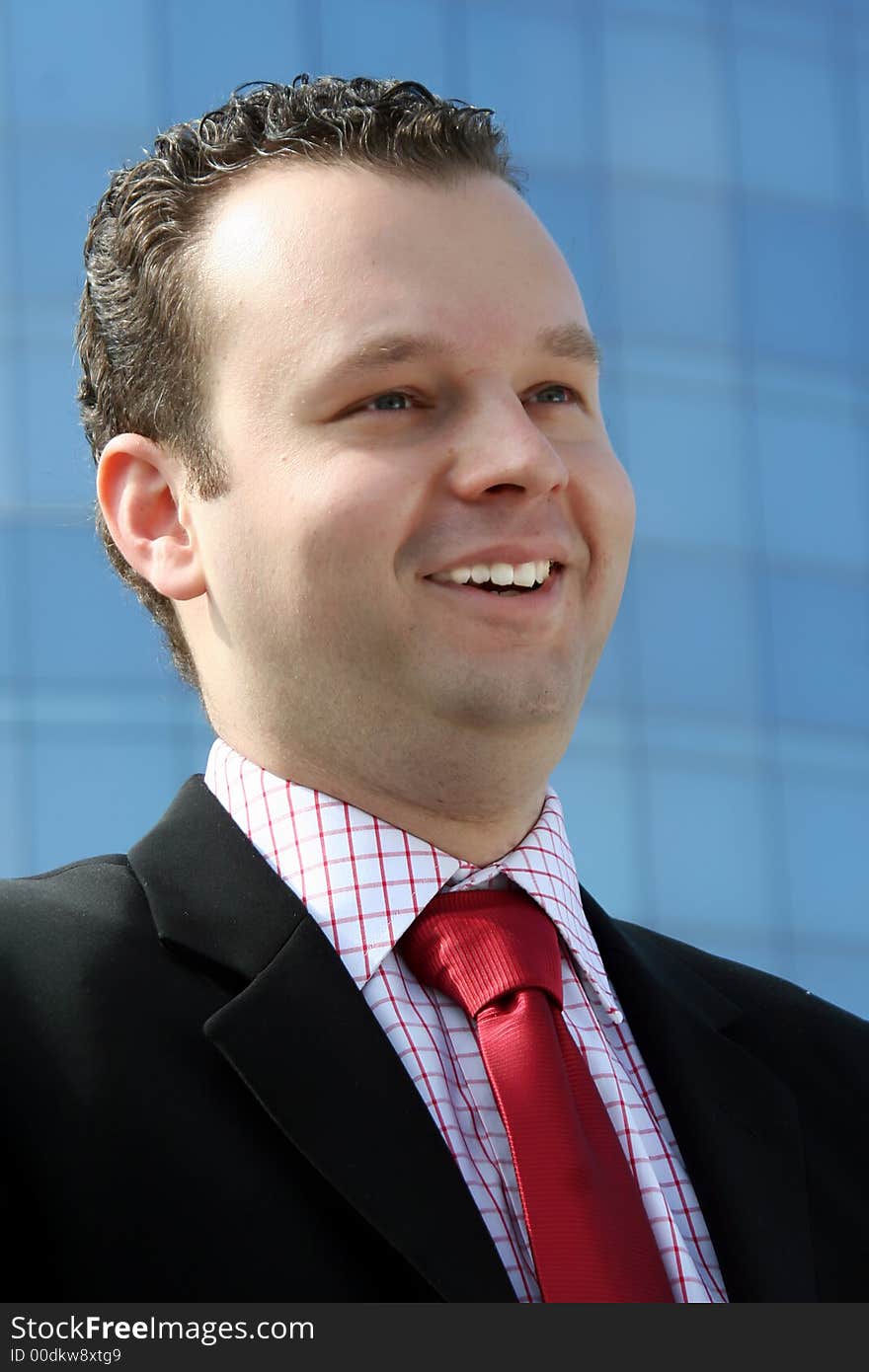 Business man smiling up the business building. Business man smiling up the business building