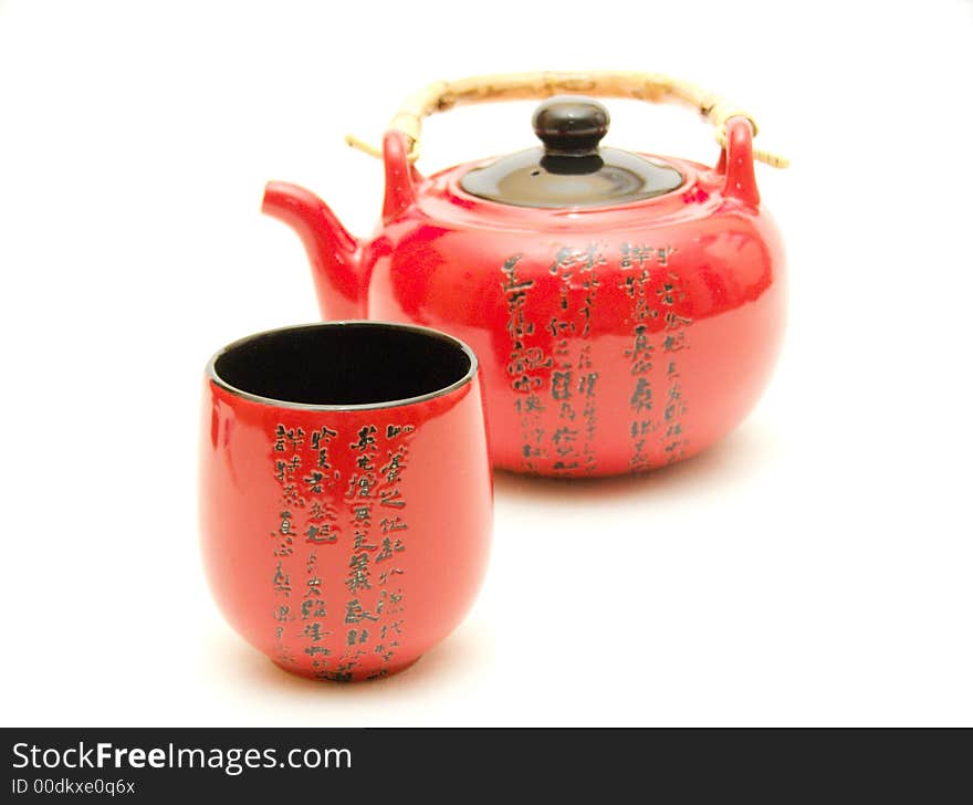 Red Chinese teapot with cup from service for tea leaves of green tea