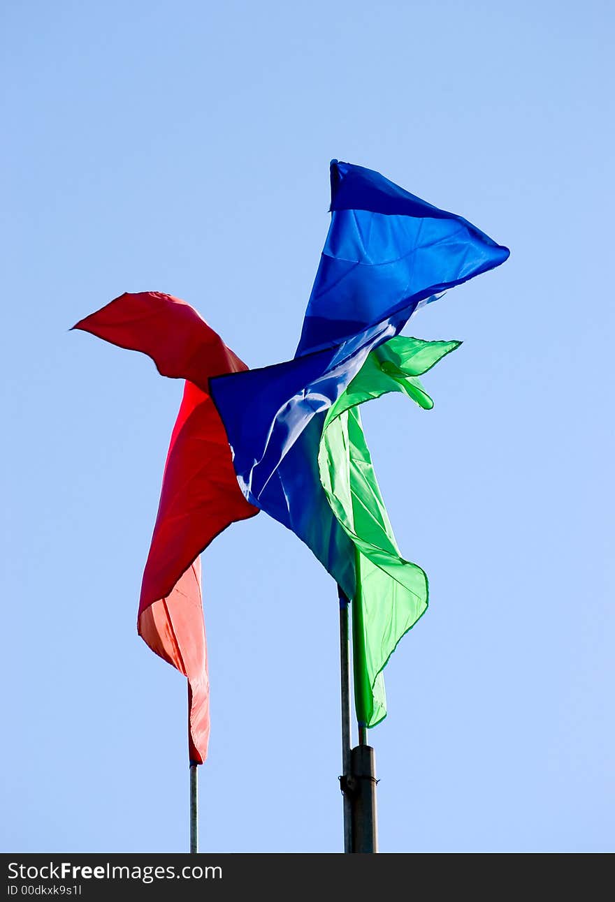 Three colour flags waving sky background