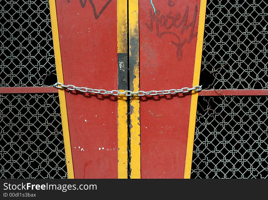 Locked, metal chain across red door