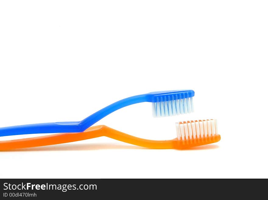 Two yellow and blue toothbrushes on  white. Two yellow and blue toothbrushes on  white