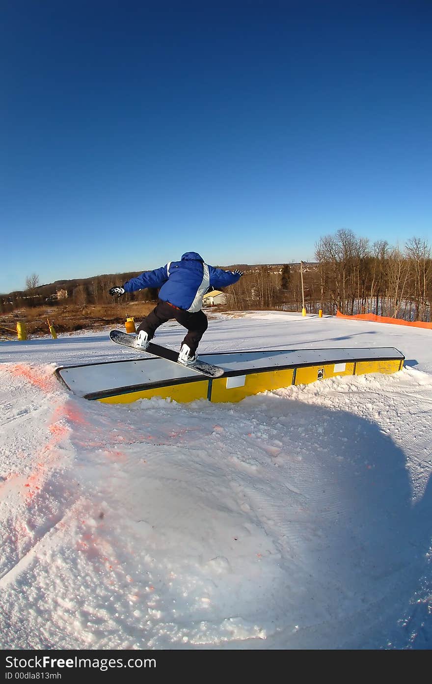 A snowboarder on a curved rail. A snowboarder on a curved rail