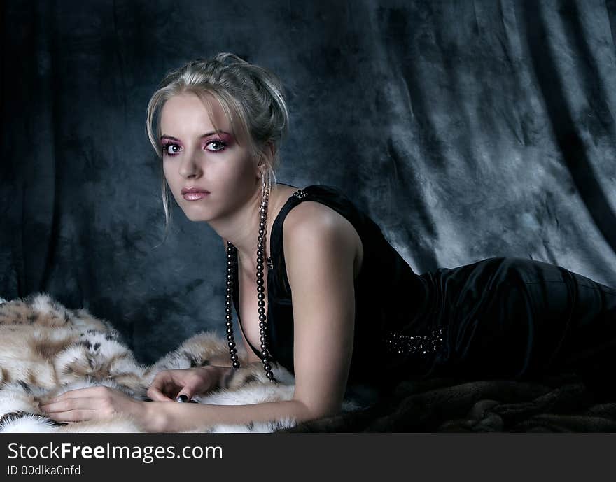 Beauty blonde girl in black dress with fur on. Beauty blonde girl in black dress with fur on