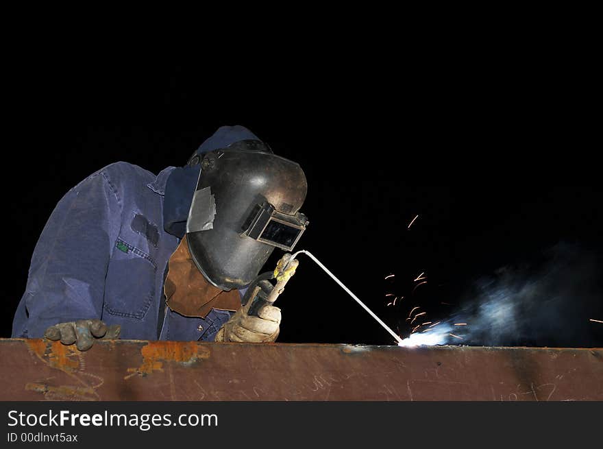 Welder working on steel at night. Welder working on steel at night