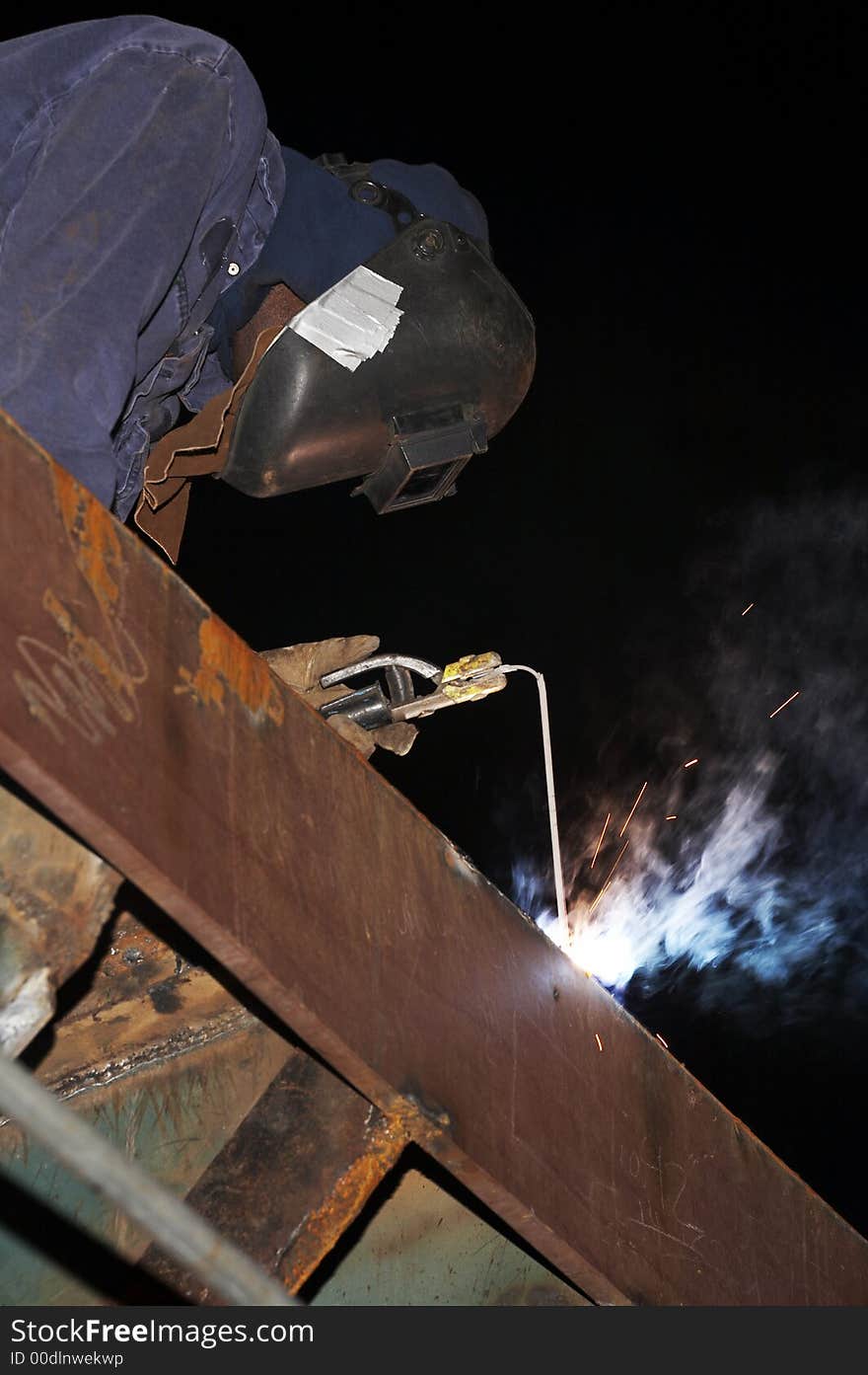 Welder working on steel at night. Welder working on steel at night