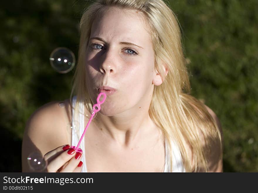 Girl Blowing bubbles at the camera.