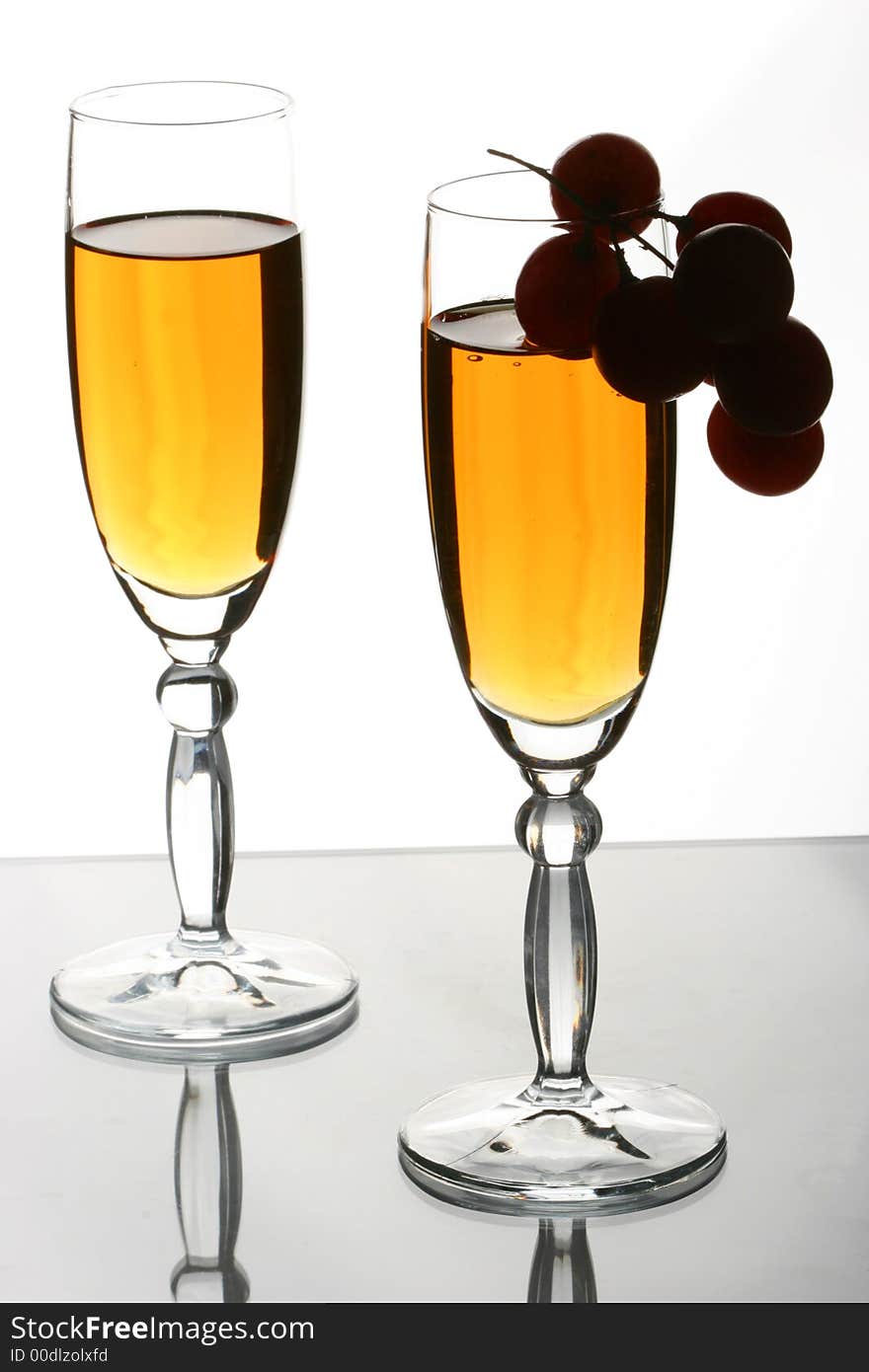 Glasses with white wine and grapevine on one of glasses. Glasses with white wine and grapevine on one of glasses