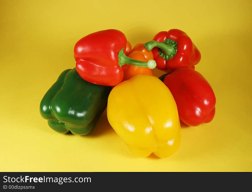 Group of the fresh bell peppers on yellow