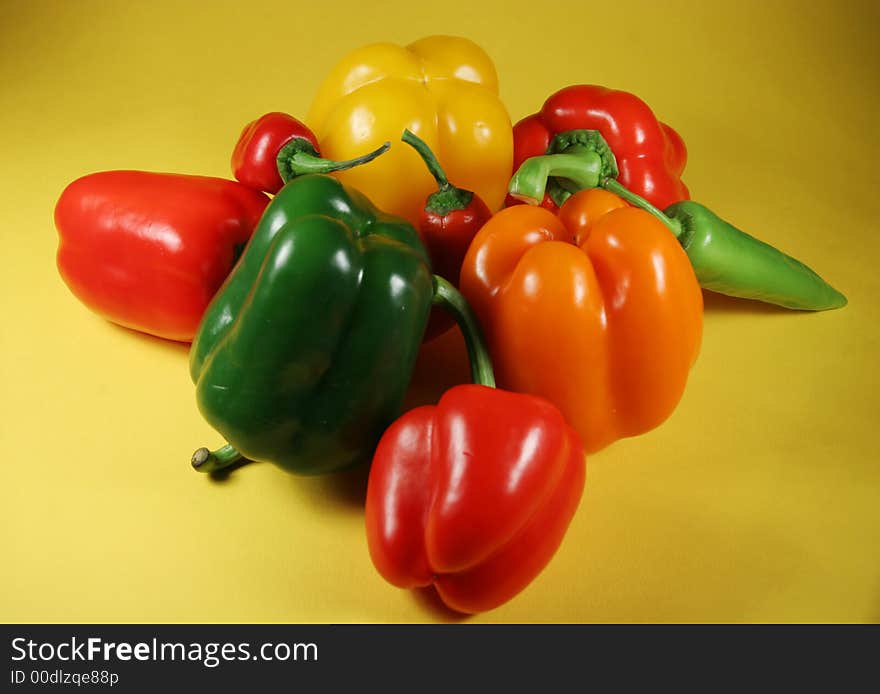 Group of the fresh bell peppers on yellow