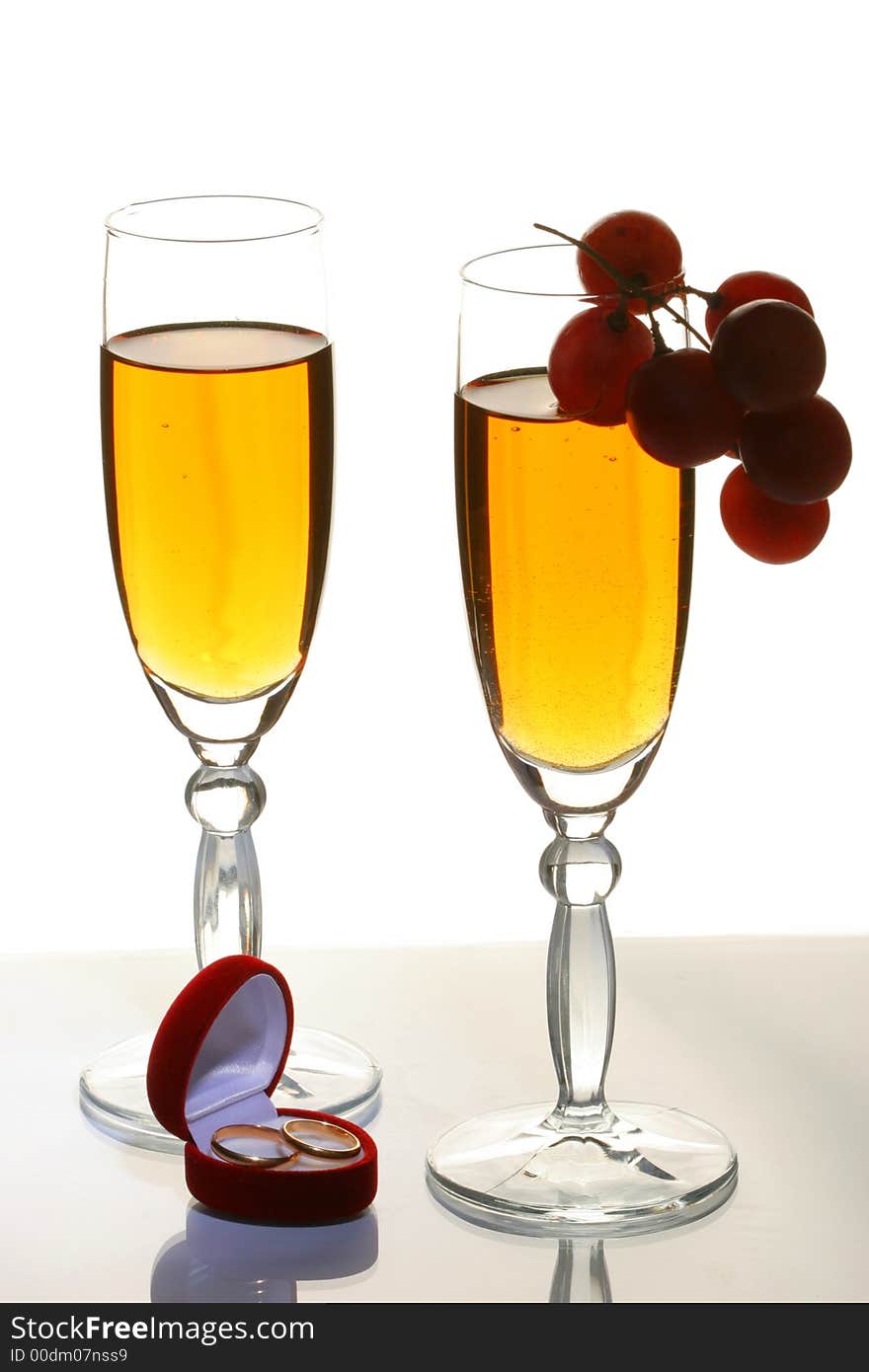 Two glasses with a champagne and wedding rings